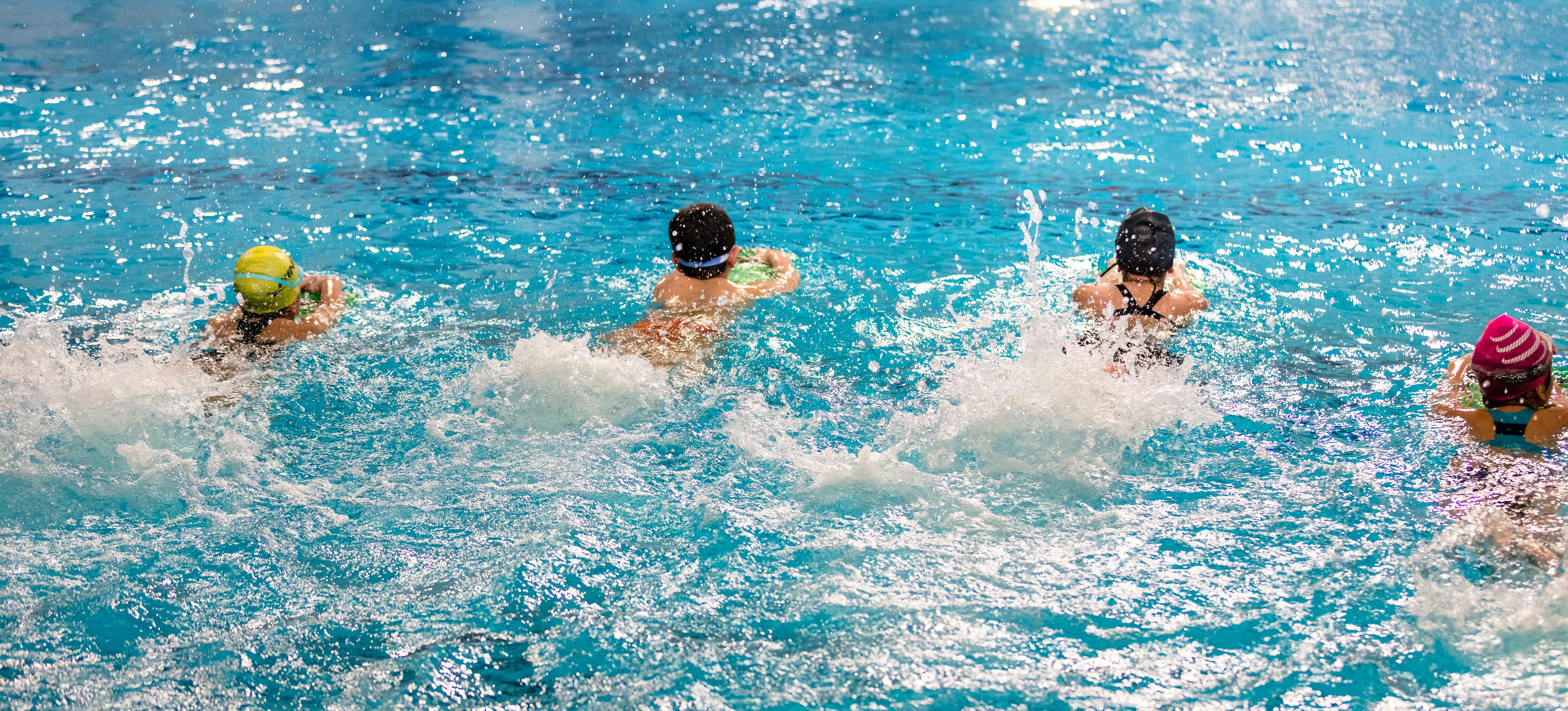 4 kids learning to swim using styrofoam board