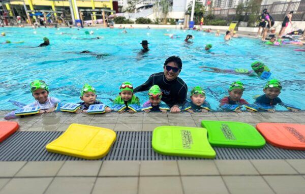 Instructor happily teaching kids how to float