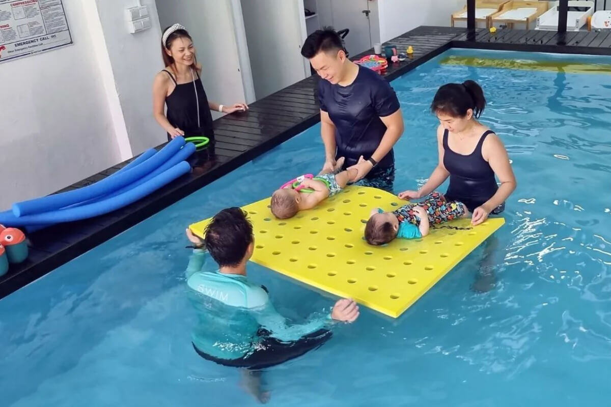 Parents helping infants learn swimming