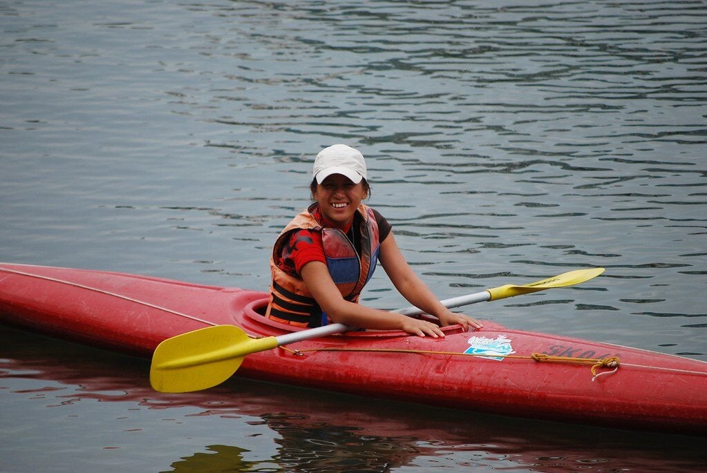 Woman paddler smiling happily in a kayak boat