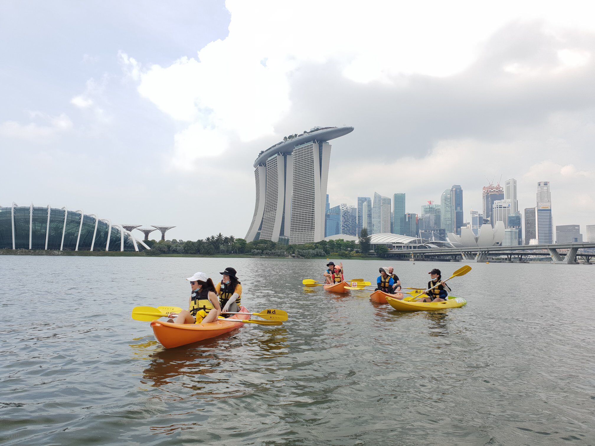 4 paddlers kayaking in front of the ferris wheel